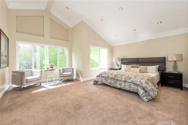 a bedroom with a bed and large windows