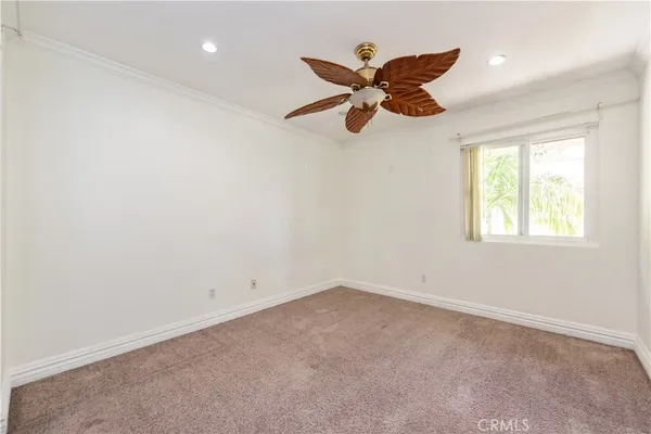 an empty room with a window and a fan