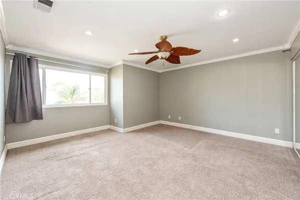 an empty room with window and ceiling fan