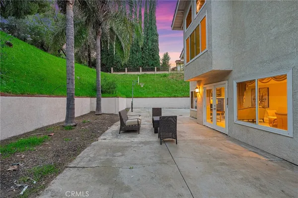a view of a house with backyard and sitting area