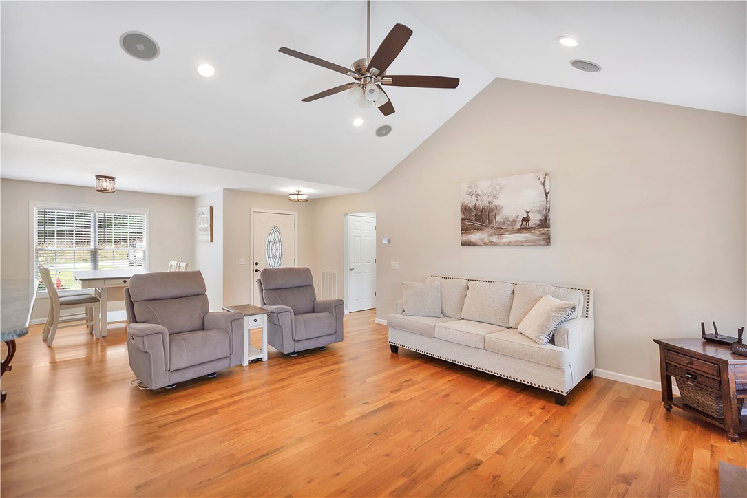 131 Morgan Road West Union, SC 29696 - Photo 4 of 39 A spacious living area features rich hardwood flooring and a vaulted ceiling with a prominent ceiling fan.