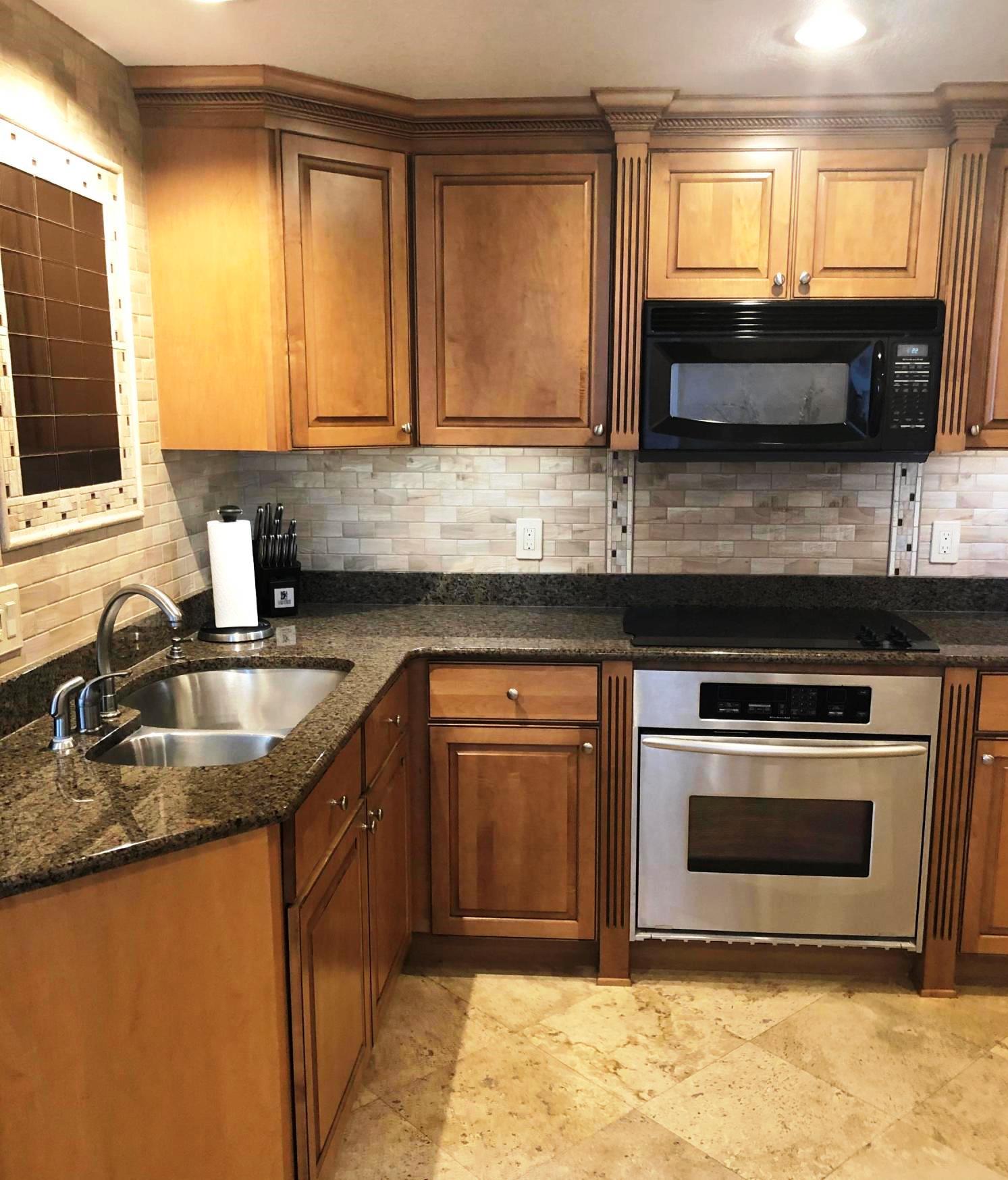 320 Harbor Boulevard, Unit 502 Destin, FL 32541 - Photo 9 of 22 a kitchen with granite countertop a sink stainless steel appliances and cabinets