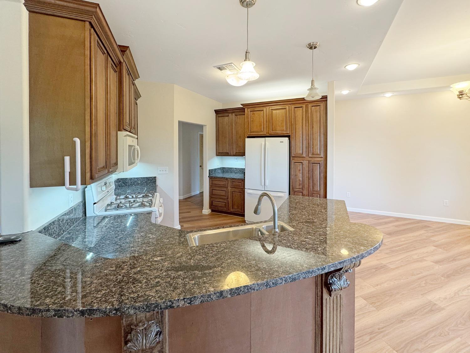 10095 Birchville Road Nevada City, CA 95959 - Photo 4 of 38 a kitchen with kitchen island granite countertop a sink and a refrigerator