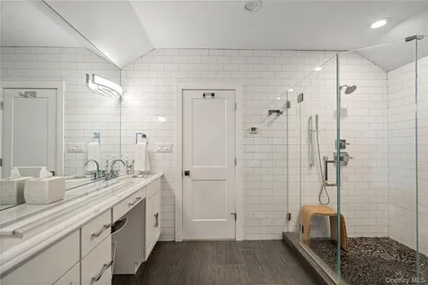 a bathroom with a double sink shower and a mirror