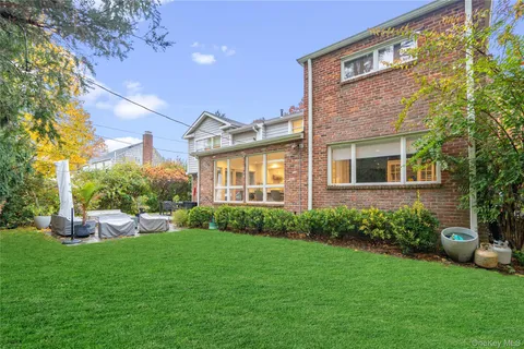 a front view of a house with a yard and trees