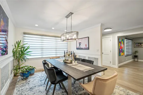 a dining room with furniture potted plants and wooden floor