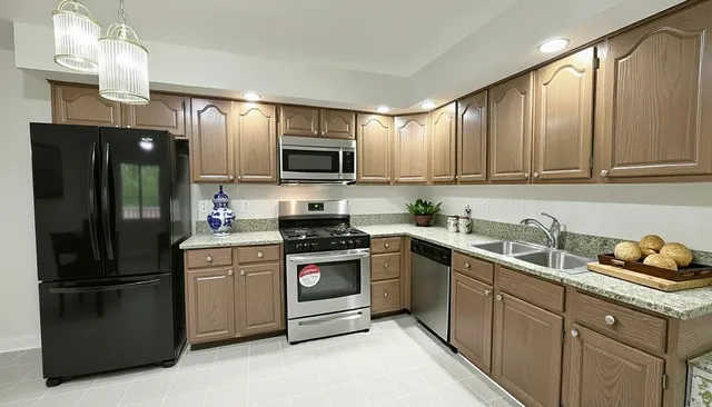 a kitchen with stainless steel appliances granite countertop a refrigerator stove and sink