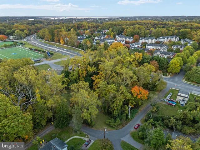 an aerial view of residential houses with outdoor space and trees