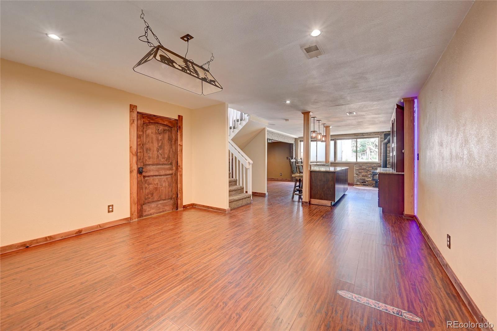 13093 Lori Drive Conifer, CO 80433 - Photo 17 of 36 a view of a living room and kitchen with wooden floor