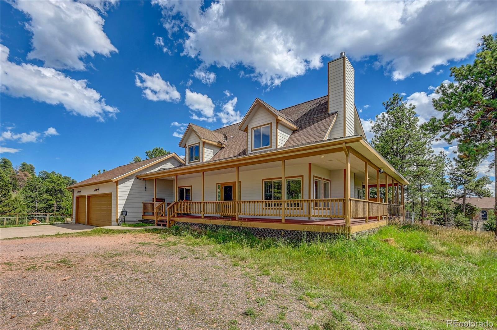 13093 Lori Drive Conifer, CO 80433 - Photo 2 of 36 a front view of a house with a garden and outdoor seating