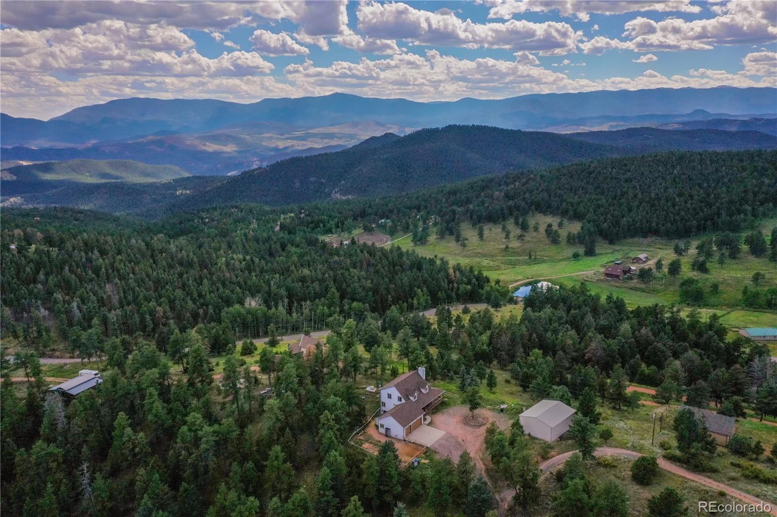 13093 Lori Drive Conifer, CO 80433 - Photo 28 of 36 a view of a lush green hillside and a houses