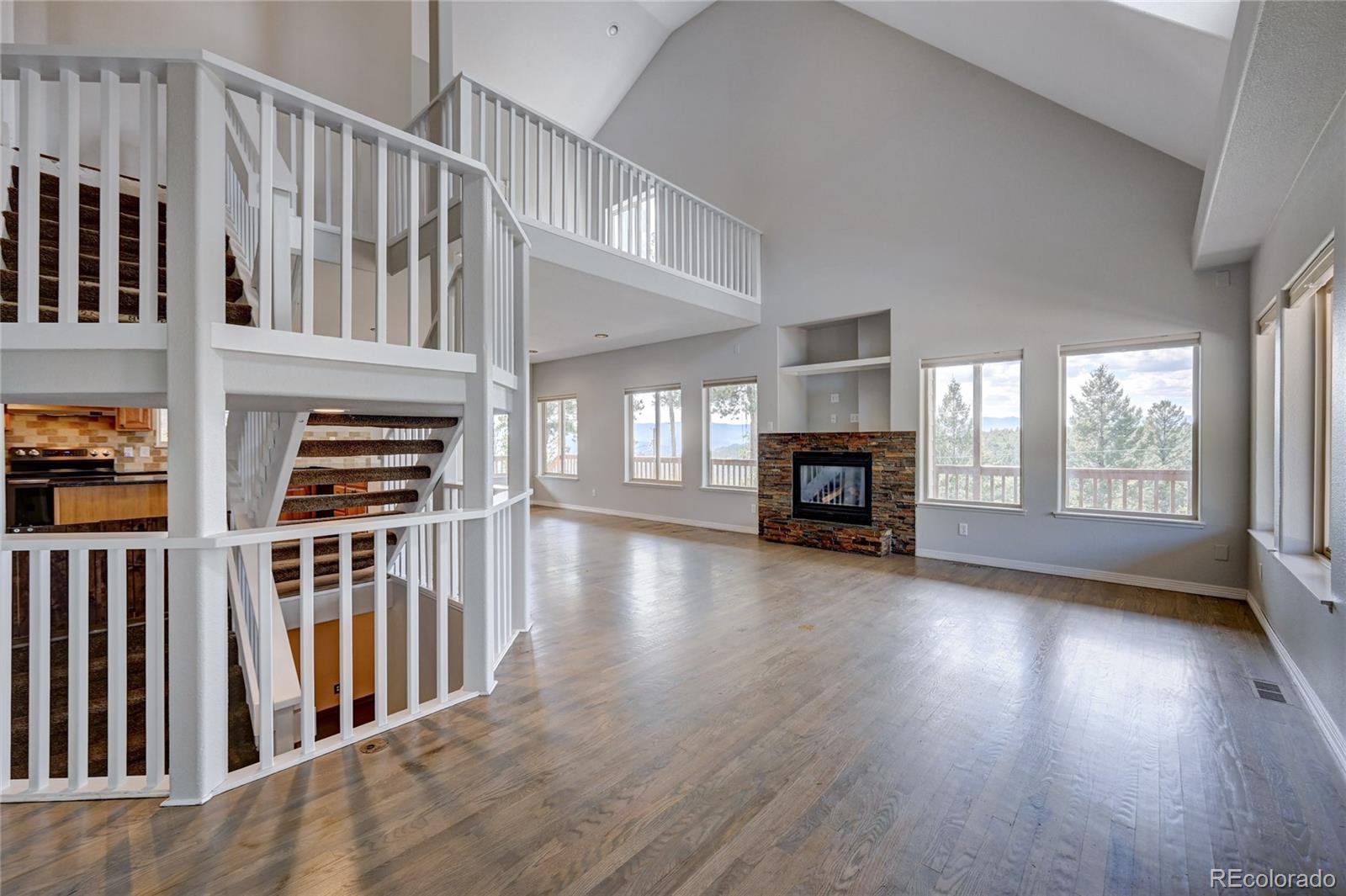13093 Lori Drive Conifer, CO 80433 - Photo 3 of 36 a view of an empty room with wooden floor fireplace and a window