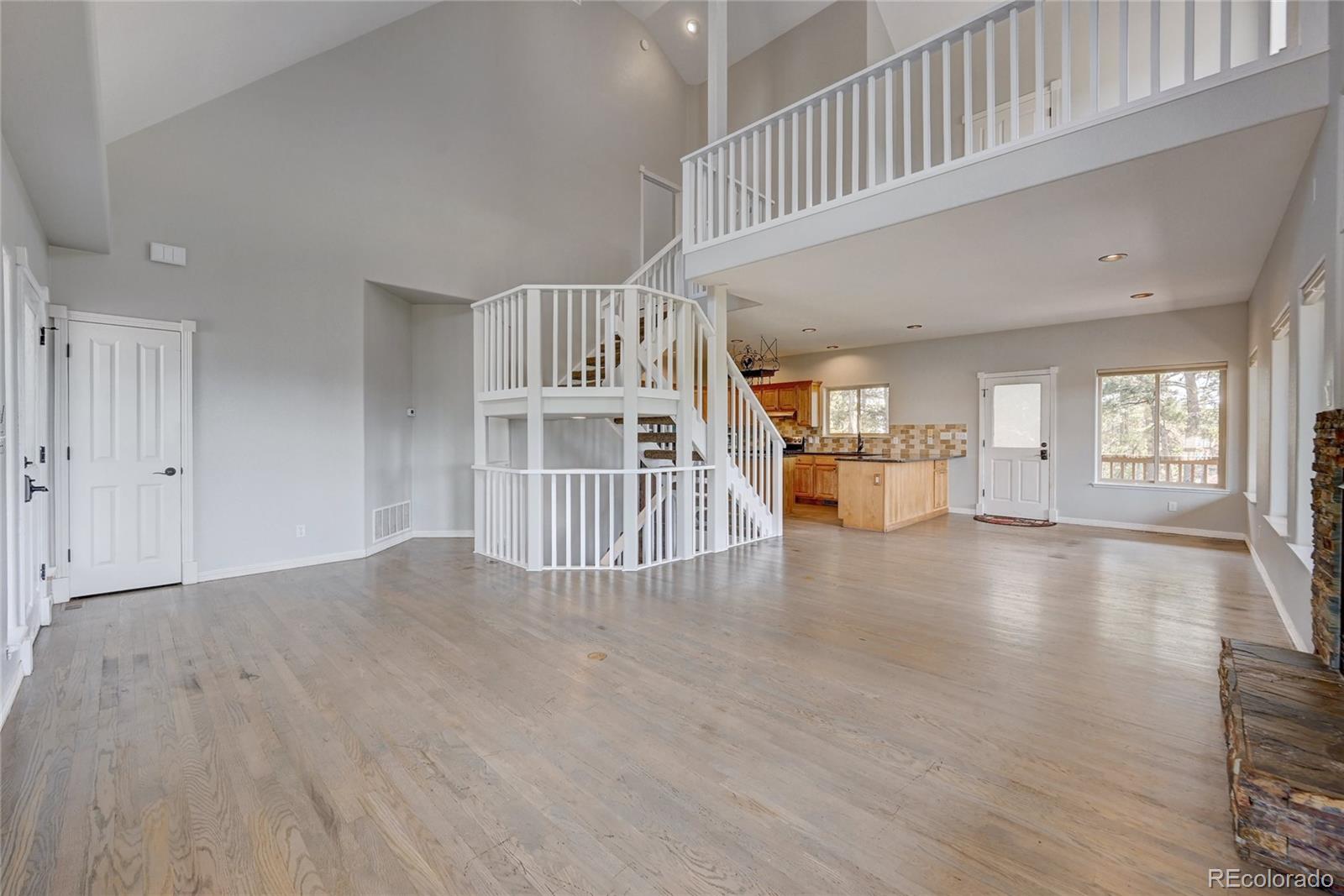 13093 Lori Drive Conifer, CO 80433 - Photo 4 of 36 a view of an empty room with wooden floor and a living room