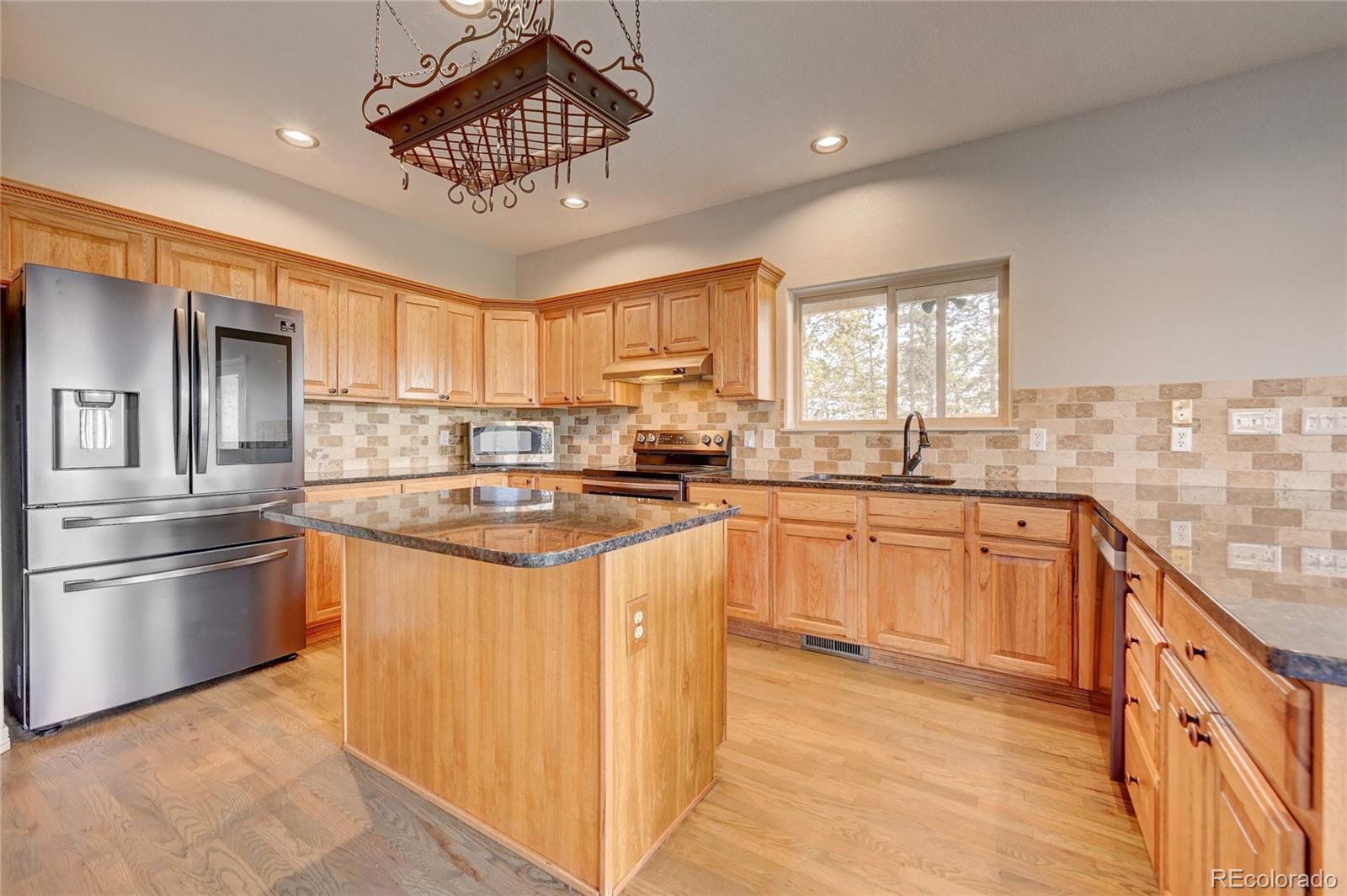 13093 Lori Drive Conifer, CO 80433 - Photo 8 of 36 a kitchen with stainless steel appliances granite countertop a stove sink and refrigerator
