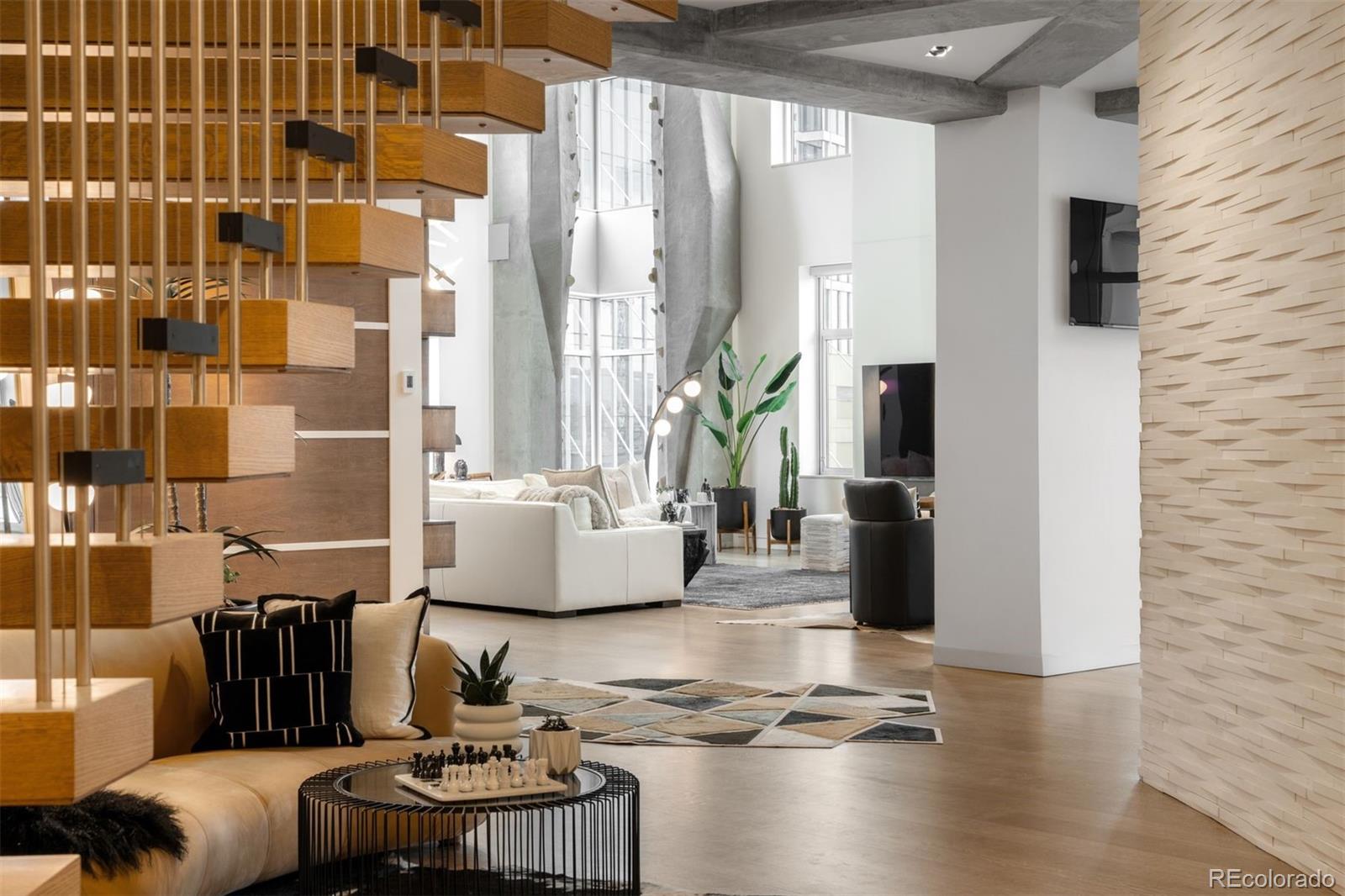 1610 Little Raven Street, Unit PH6 Denver, CO 80202 - Photo 20 of 41 a living room with couches and a dining table with wooden floor