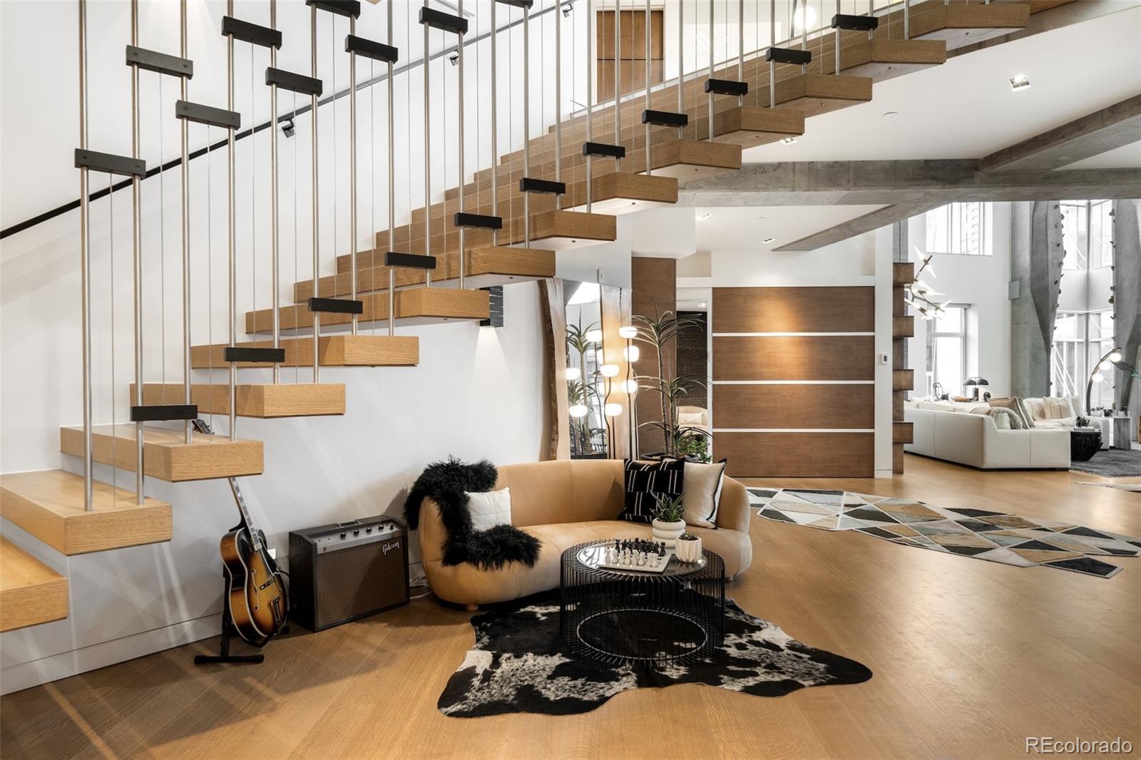 1610 Little Raven Street, Unit PH6 Denver, CO 80202 - Photo 21 of 41 a living room with couches chairs and stairs with wooden floor