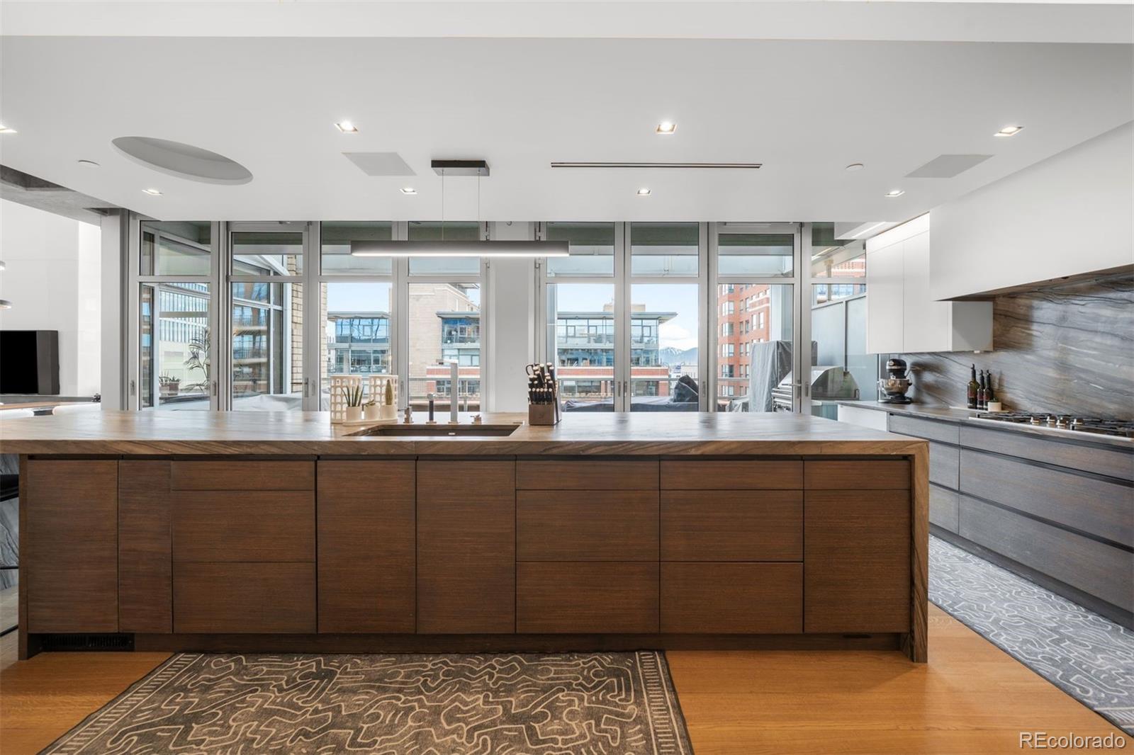 1610 Little Raven Street, Unit PH6 Denver, CO 80202 - Photo 10 of 41 a kitchen with a sink wooden cabinets and counter space