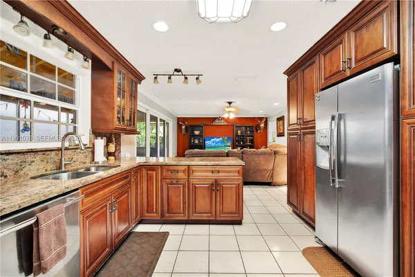 a kitchen with stainless steel appliances granite countertop a refrigerator a sink and dishwasher