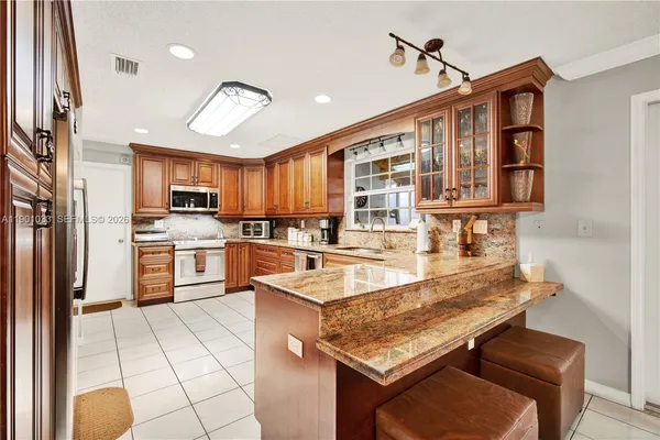 a kitchen with stainless steel appliances granite countertop a sink and cabinets
