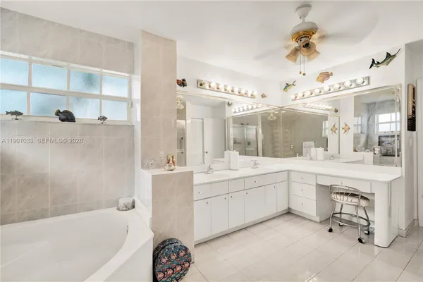 a spacious bathroom with a tub sink and mirror