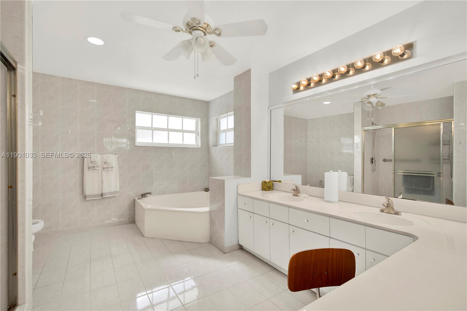 10825 Southwest 91st Lane Miami, FL 33176 - Photo 37 of 52 a en suite bathroom with a double vanity sink a mirror and a bathtub