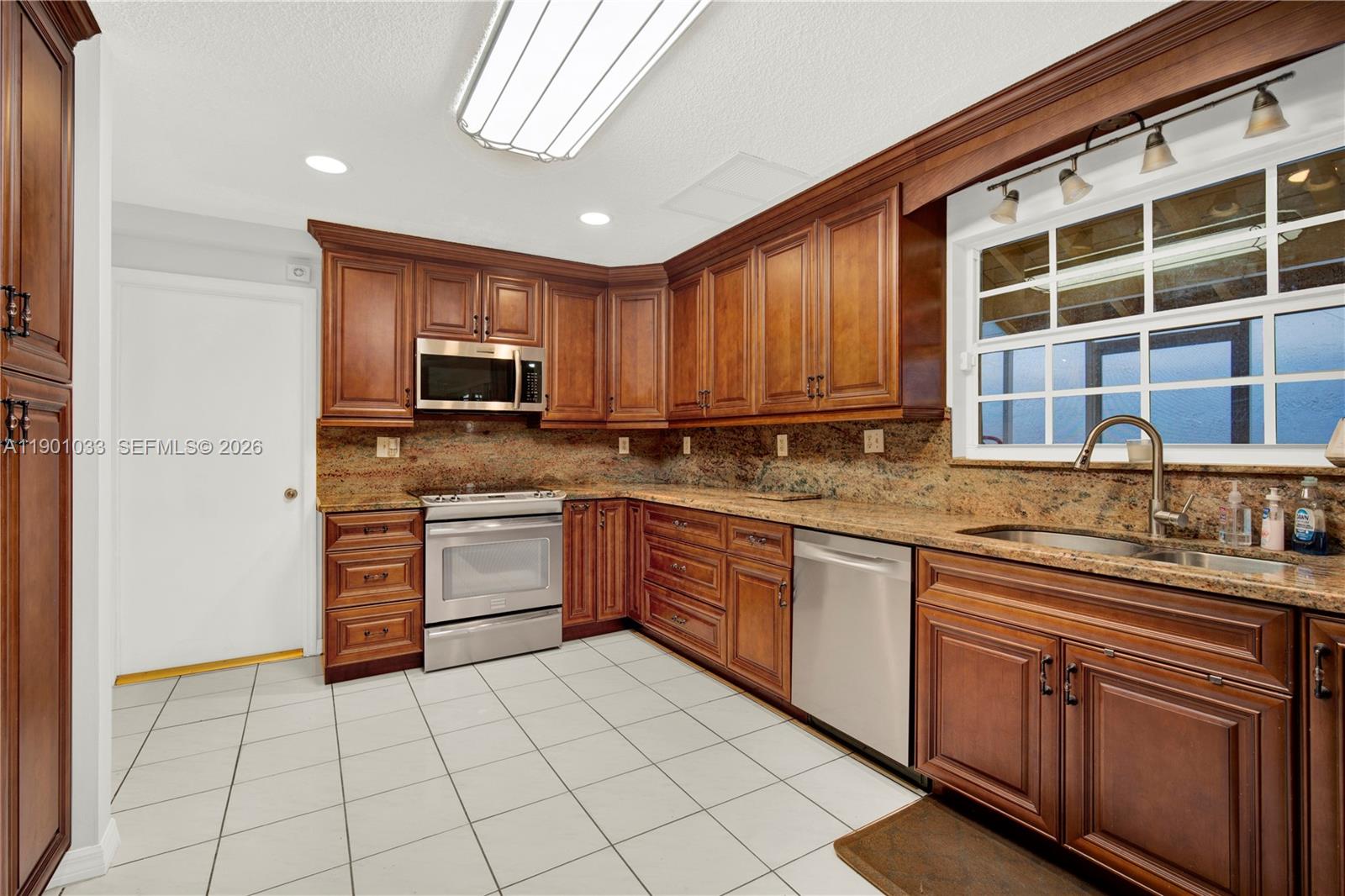 10825 Southwest 91st Lane Miami, FL 33176 - Photo 6 of 52 a kitchen with stainless steel appliances granite countertop a stove sink and cabinets