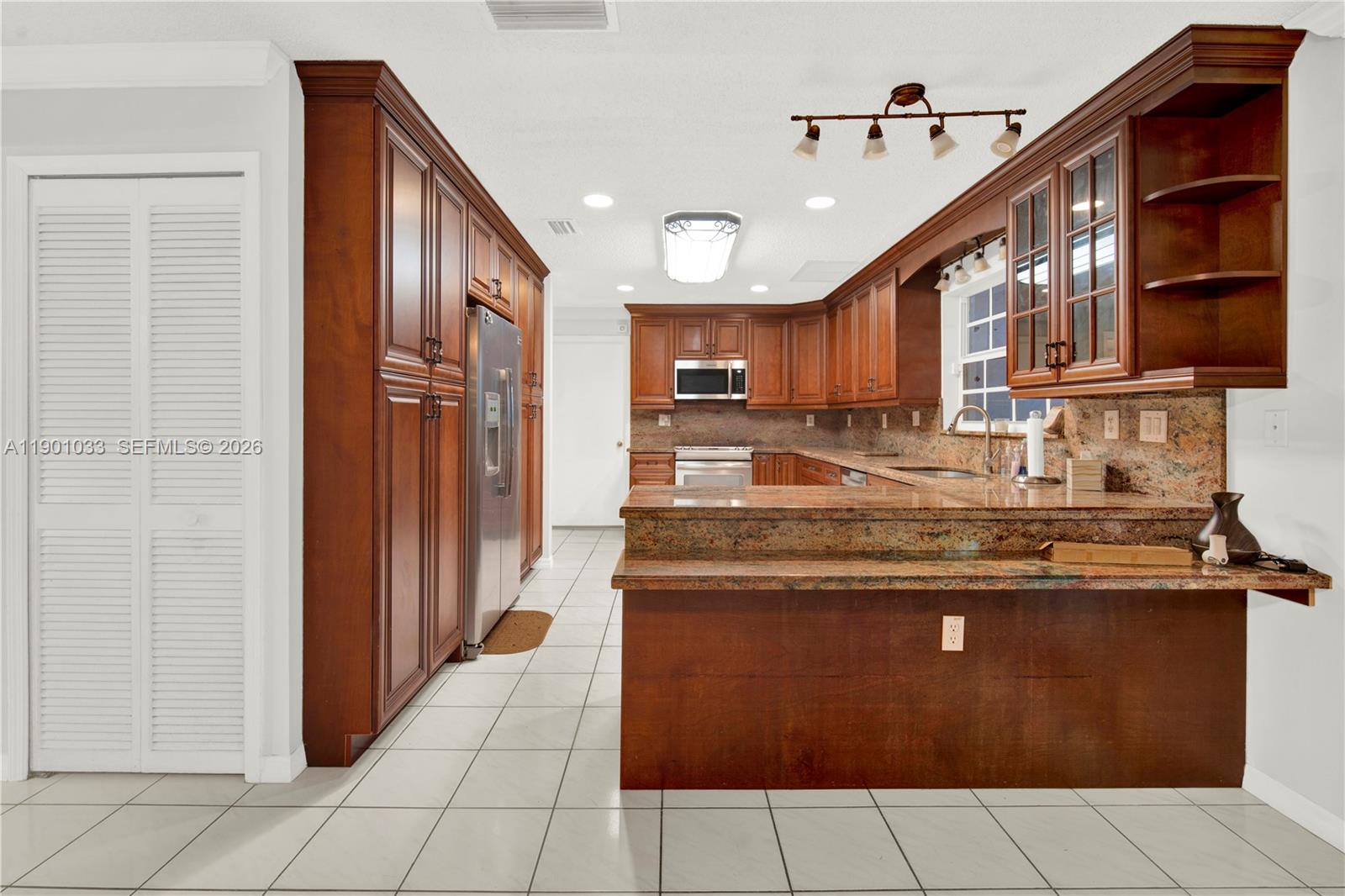 10825 Southwest 91st Lane Miami, FL 33176 - Photo 7 of 52 a kitchen with stainless steel appliances granite countertop a stove and a refrigerator