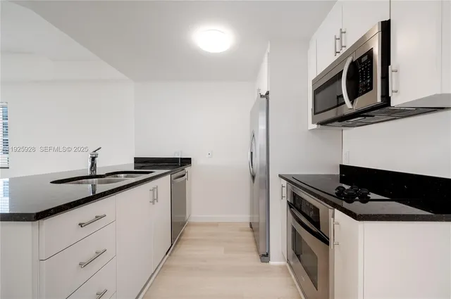 a kitchen with stainless steel appliances granite countertop a sink stove and microwave