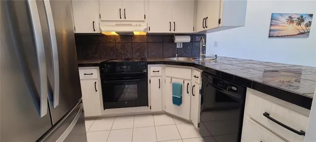 a kitchen with stainless steel appliances granite countertop a stove a refrigerator and a sink