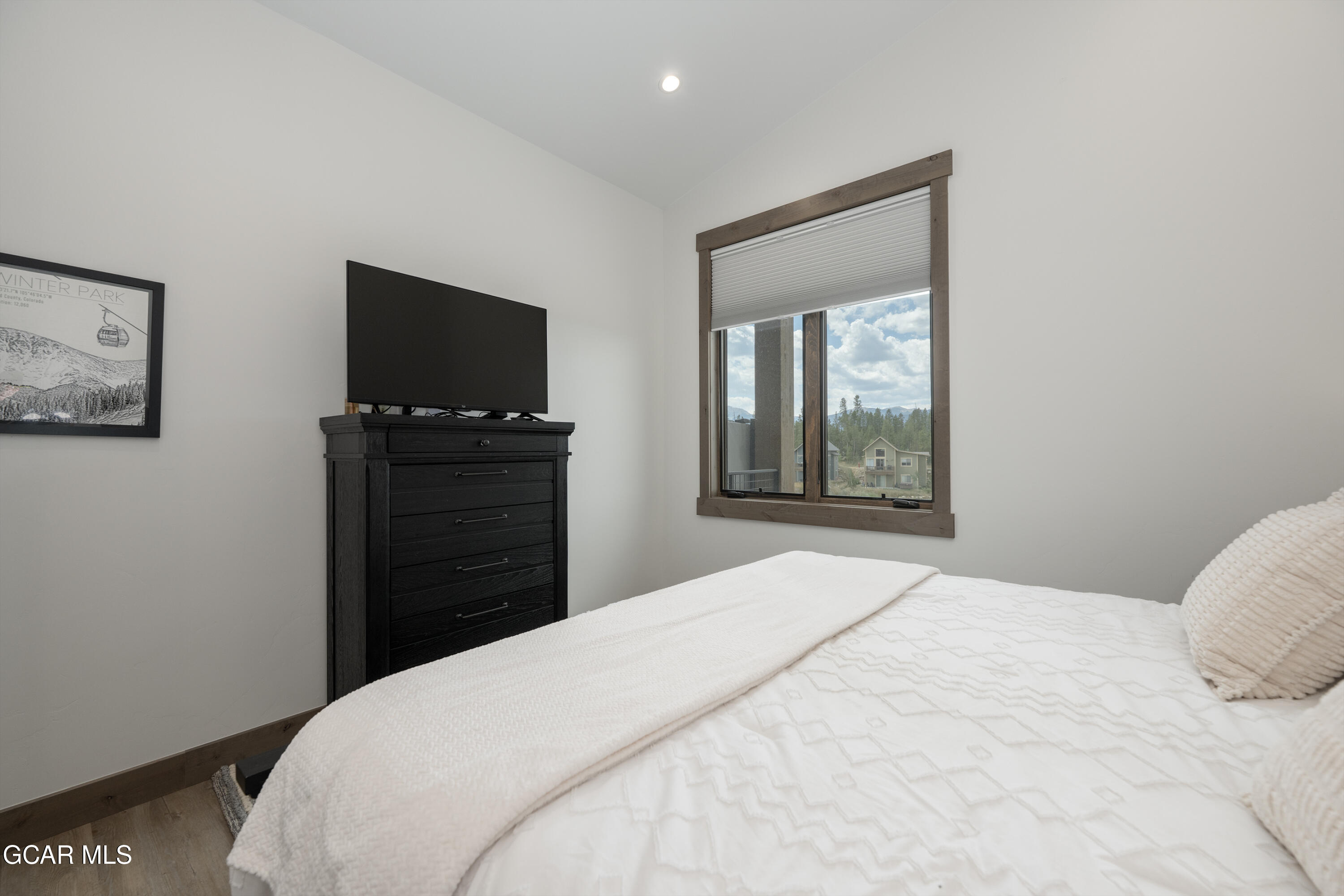96 Meadow Trail, Unit G304 Fraser, CO 80442 - Photo 17 of 37 a bedroom with a bed and a flat screen tv