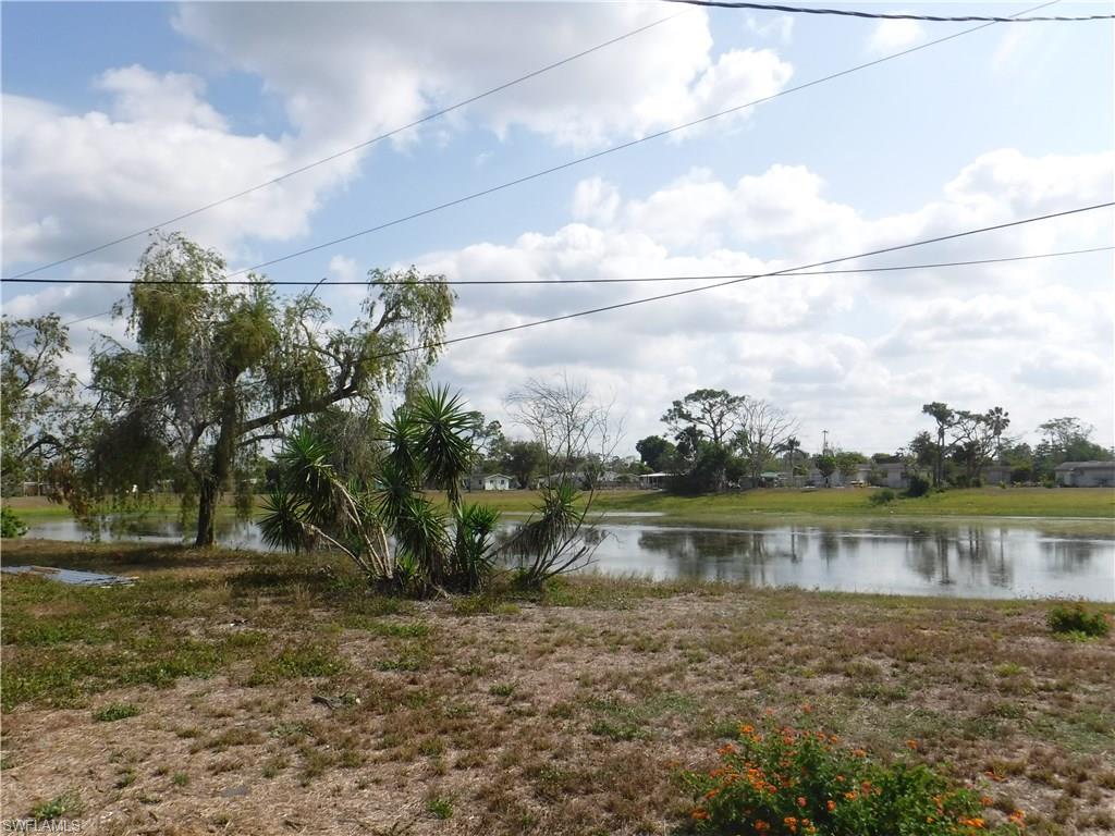 106 Oleander Road Lehigh Acres, FL 33936 - Photo 16 of 17 a view of a lake with houses in the back