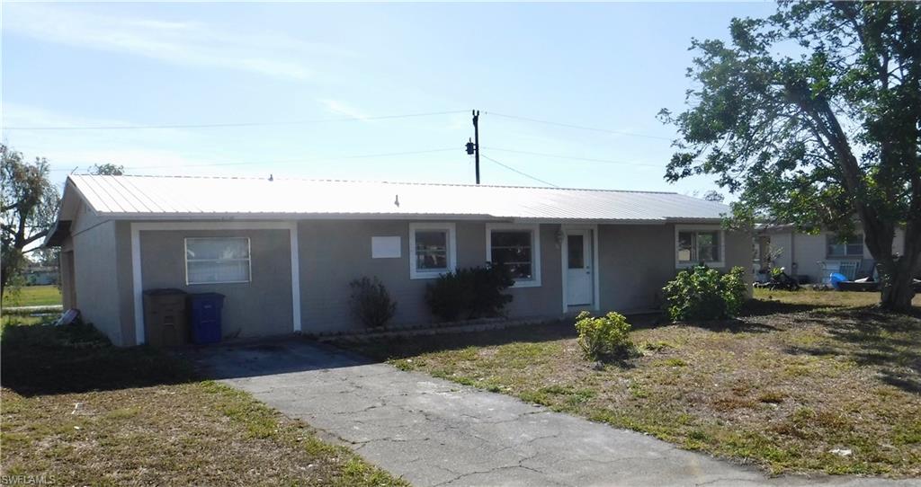 106 Oleander Road Lehigh Acres, FL 33936 - Photo 6 of 17 a front view of a house with garden