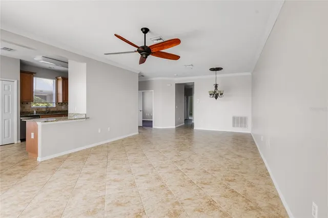 a view of a livingroom with a ceiling fan and kitchen space