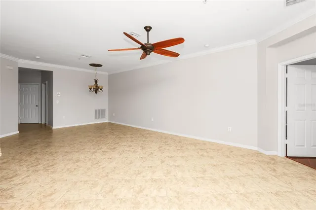 an empty room with a ceiling fan and window