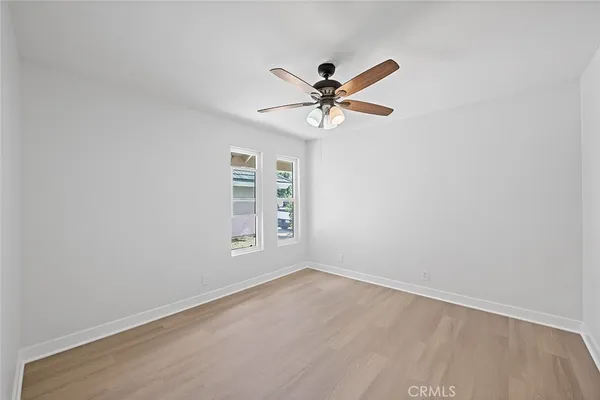an empty room with a window and a fan