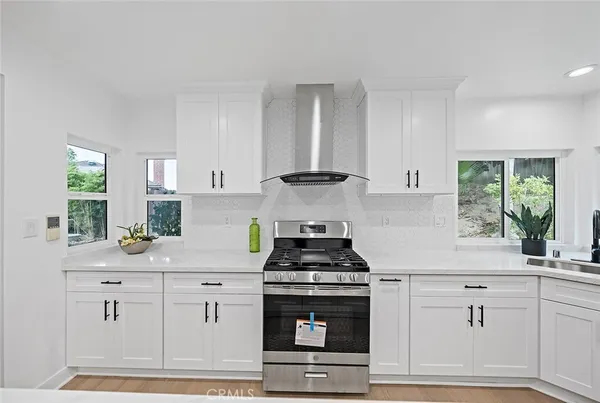 a kitchen with white cabinets and appliances
