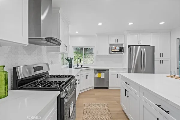 a kitchen with kitchen island wooden cabinets a sink stove and refrigerator