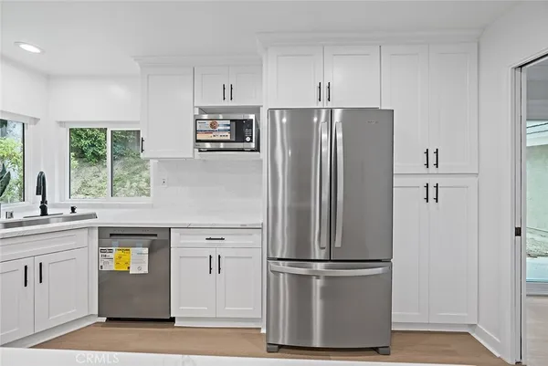 a kitchen with stainless steel appliances a refrigerator sink and microwave