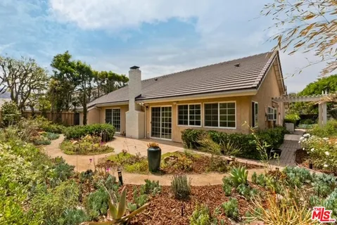 a front view of a house with a yard and potted plants