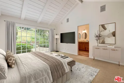 a bedroom with a large bed and a flat screen tv