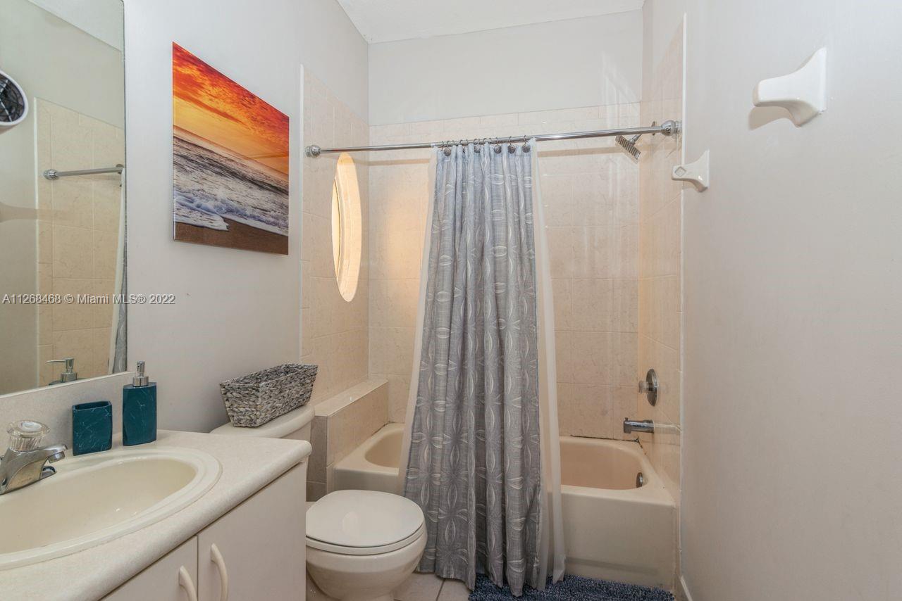 2240 Northeast 37th Terrace Homestead, FL 33033 - Photo 13 of 18 a bathroom with a sink a toilet and shower curtain