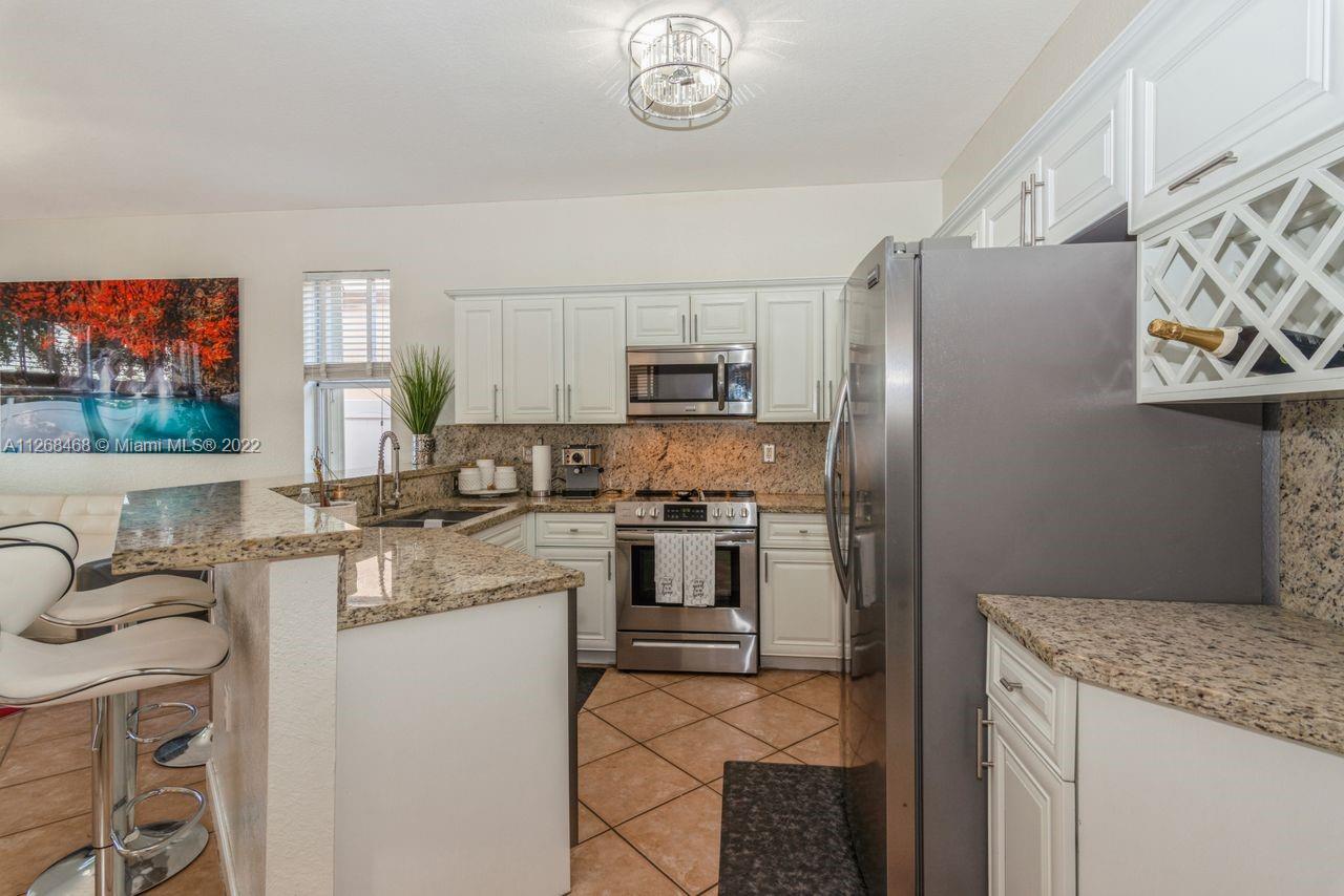 2240 Northeast 37th Terrace Homestead, FL 33033 - Photo 5 of 18 a kitchen with stainless steel appliances granite countertop a refrigerator and a stove top oven