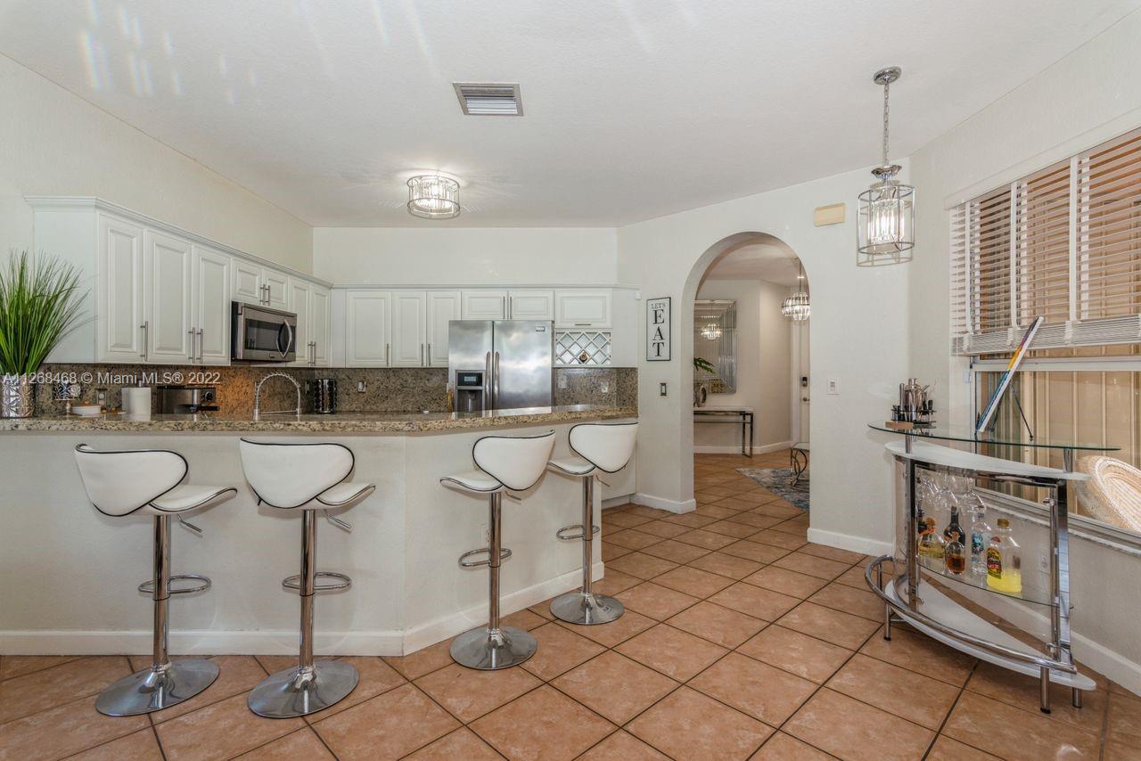 2240 Northeast 37th Terrace Homestead, FL 33033 - Photo 7 of 18 a kitchen with stainless steel appliances kitchen island granite countertop a stove a sink and cabinets