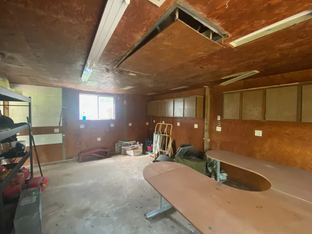 a view of backyard with wooden fence and a large tree