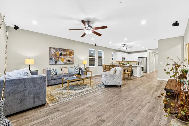 a living room with furniture kitchen view and a flat screen tv