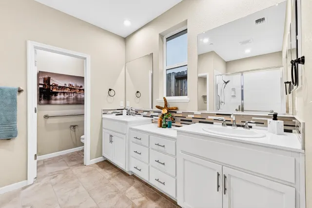 a spacious bathroom with a double vanity sink double and mirror