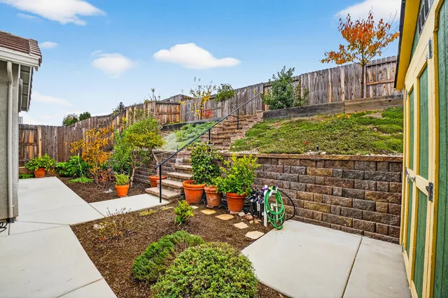 a view of a patio with table and chairs potted plants and wooden fence