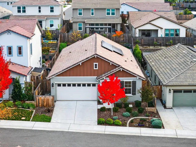 an aerial view of a city with lots of residential buildings ocean and mountain view in back