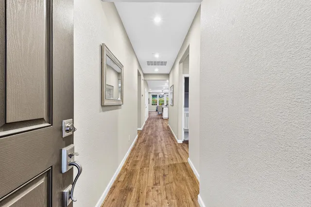 a view of a hallway with wooden floor and staircase