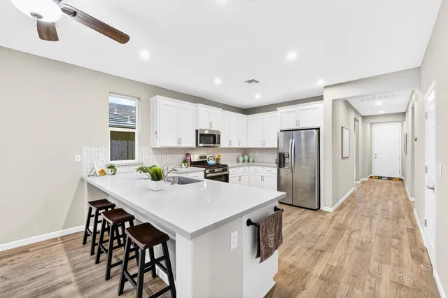 a kitchen with refrigerator and white cabinets